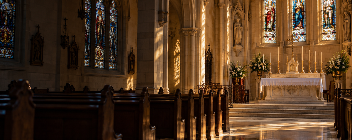Sunlight through stained glass above pews and an altar in a peaceful church